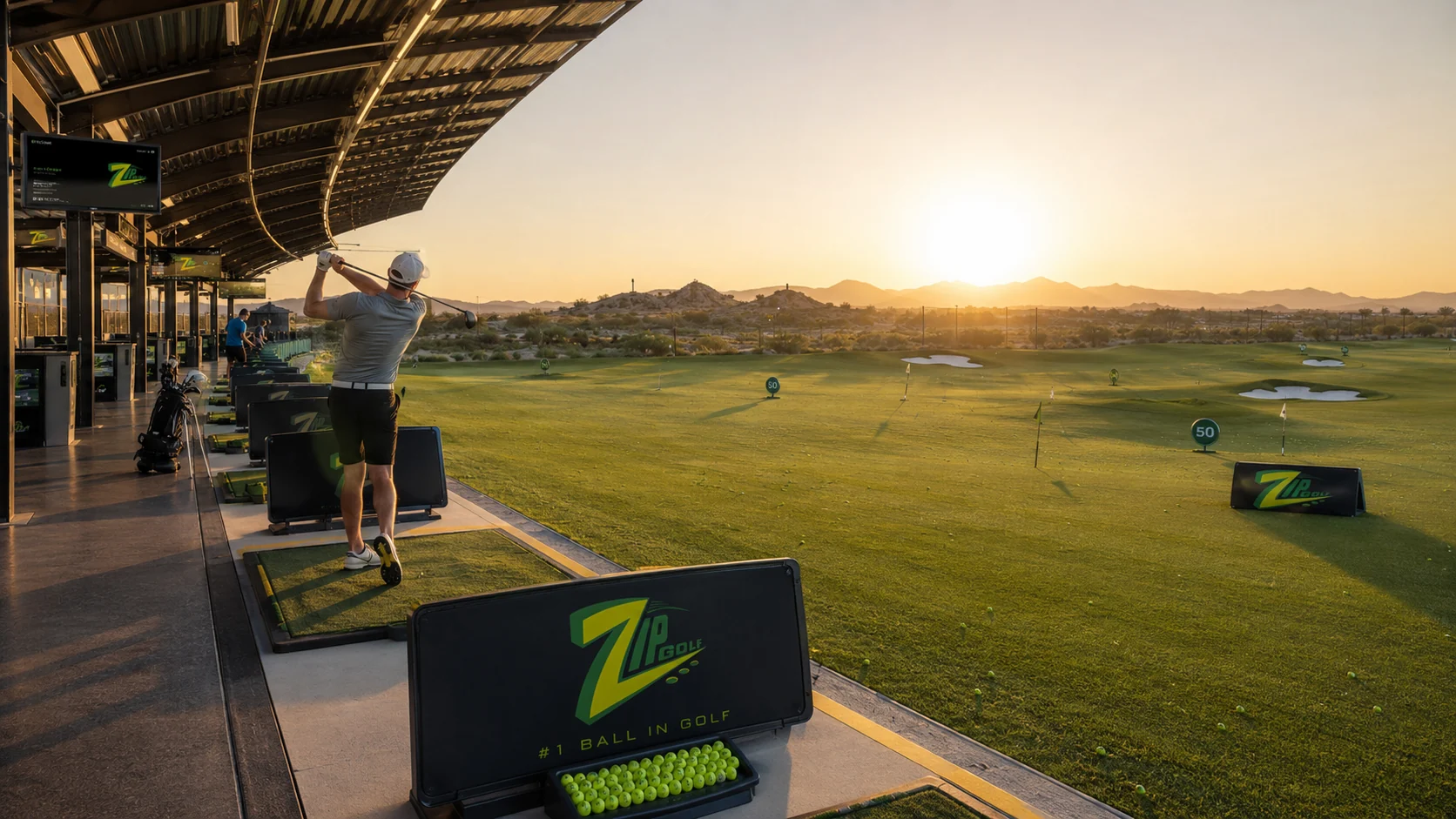 Zip Golf driving range at sunrise with golfers hitting balls